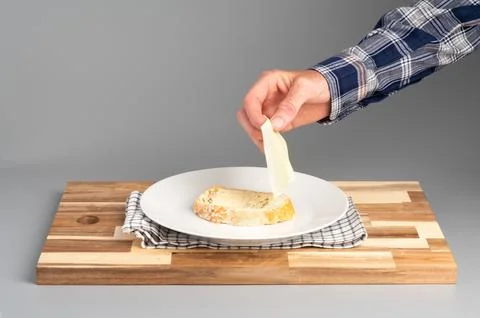 Placing Cheese on Bread Slice Stock Photos