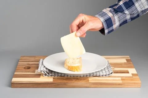 Placing Cheese on Bread Slice Stock Photos