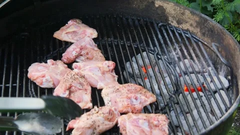 Placing chicken thighs on a hot grill rack onto Charcoal Barbecue in Sunny .. Stock Footage 337410236