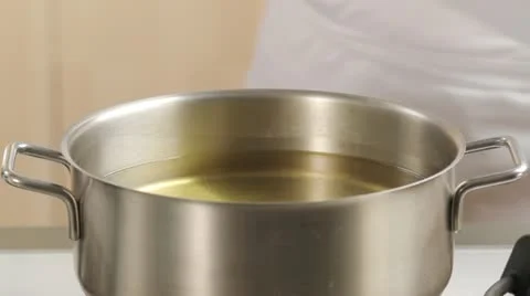 Placing chips in the deep-frying fat using a slotted spoon Stock-Footage 24664495