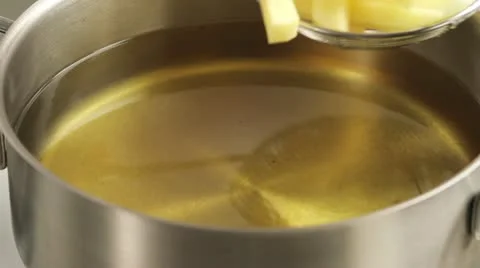 Placing chips in the deep-frying fat using a slotted spoon Stock-Footage 24664503