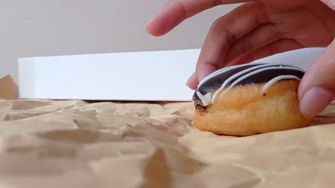 Placing a chocolate donut on a brown table Stock Footage 149956472