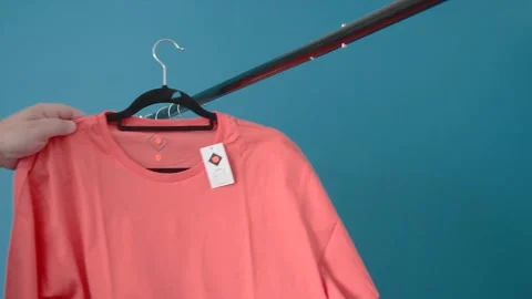 Placing clothes on a sale hanger in a store Stock Footage