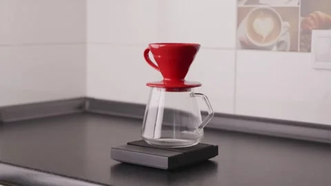 Placing coffee server with red V60 dripper on digital scales Stock Footage 332720231