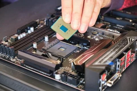 Placing a computer chip (CPU) in its socket on a black motherboard. Custom PC Foto stock