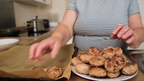 Placing cooked cutlets onto baking sheet. Unrecognizable person arranging fried Stock Footage 316040897