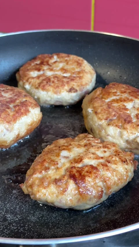 Placing cooked cutlets onto baking sheet. Unrecognizable person arranging fried Stock Footage 318447317