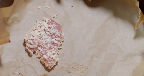 Placing crispy-coated pork onto the tray lined with baking paper before cooking  Stock Footage 312312069