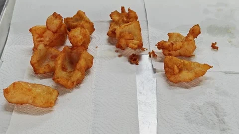 Placing crispy fried fish onto paper towels to drain excess oil. Stock Footage 342737414