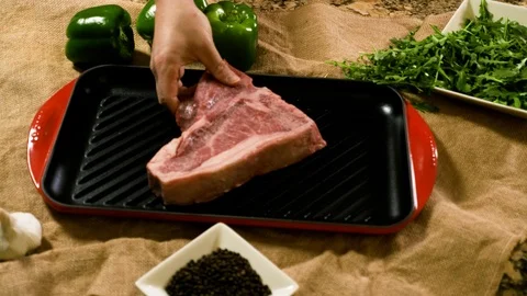 Placing cut of raw meat on a tray Stockbeeldmateriaal 102609225