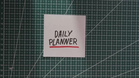 Placing Daily Planner paper note centrally on green cutting mat Stock Footage 341269394