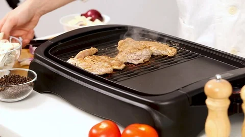 Placing different vegetables on a grill with pork meat Stock Footage 85320238