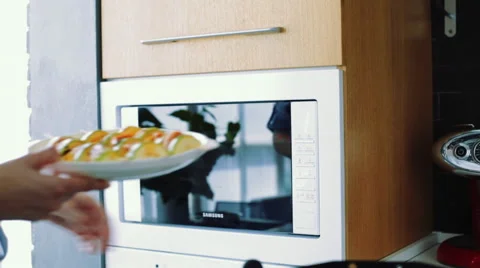 Placing a dish into microwave Stock-Footage 55703572