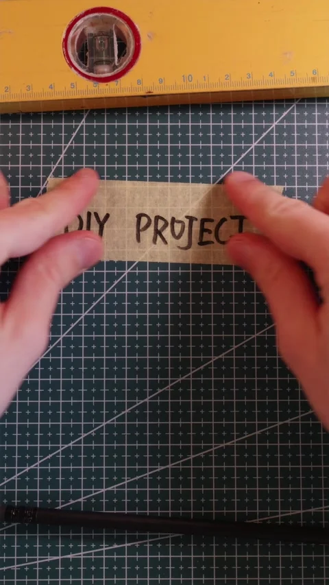 Placing DIY PROJECT handwritten tape sticker on mat. Stock Footage 337816354