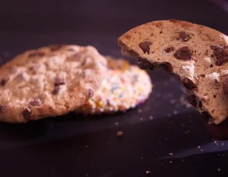Placing down chocolate Chip and Christmas Cookies After Bite Stock Photos