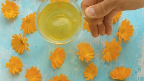 Placing down cup of calendula tisane Stock Footage 136933289
