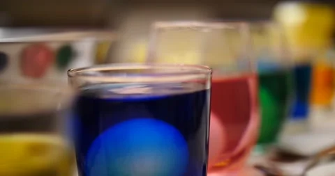 Placing Easter egg into blue dye getting ready for the Holiday  Stock Footage 151503102