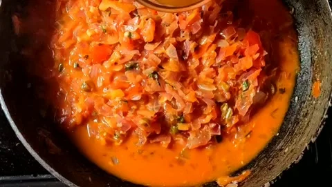 Placing egg on top of frying onions and tomatoes. Stock Footage 201509853