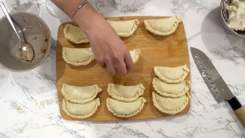 Placing empanadas on kitchen table 2 Stock Footage 205969549
