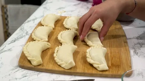 Placing empanadas on kitchen table Stock Footage 205966715