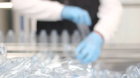 Placing empty bottles on conveyor belt Stock Footage 77052874