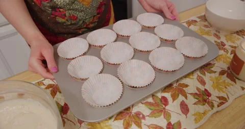 Placing empty cupcake tray on counter with wrappers Stock Footage 249351476