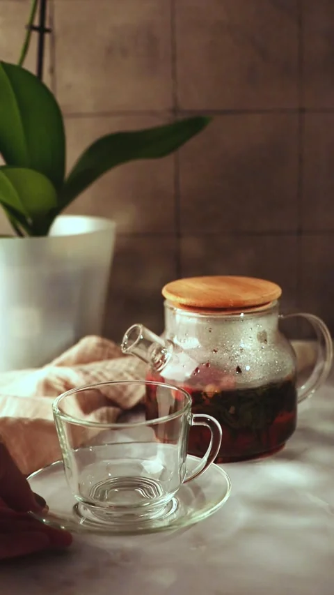 Placing Empty Glass Cup Next to Brewed Cranberry Tea Pot Stock Footage 344043776