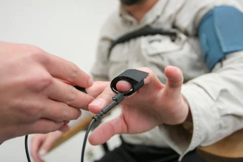 Placing equipment for interrogation of a man with lie detector. Stock Photos