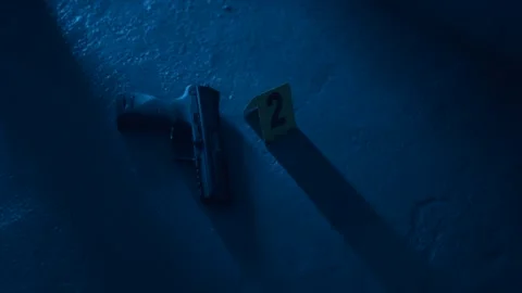 Placing evidence marker beside hand gun Stock Footage 336739796