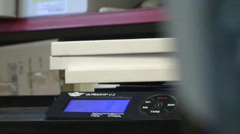 Placing Flat Boxes on a set of Digital Scales Stock Footage 62680109
