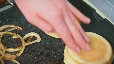 Placing, flipping, and removing bun bread from a grilling pan in 4K. Stock Footage 153755173