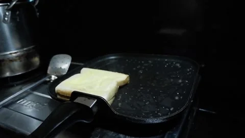 Placing four bread into hot flat frying pan Stock Footage 278510017