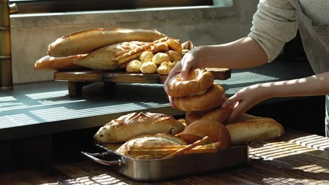 Placing Fresh Bread on Tray over Sunlit Table Close Up Stock Footage 335732950
