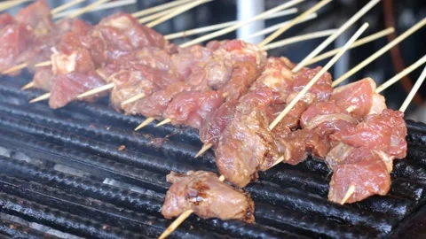 Placing fresh meat on grill, ready for grilling skewed kebab or mishkaki Stock Footage 161253221