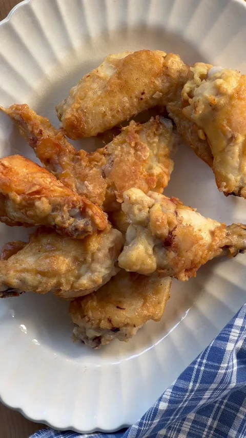 Placing fried chicken wings on platter Stock Footage 220436815