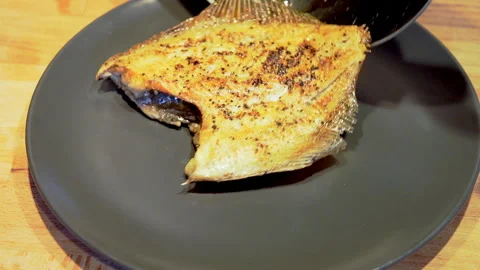 Placing fried flounder on a plate. Fried fish on a plate Healthy eating concept. Stock Footage 267899318