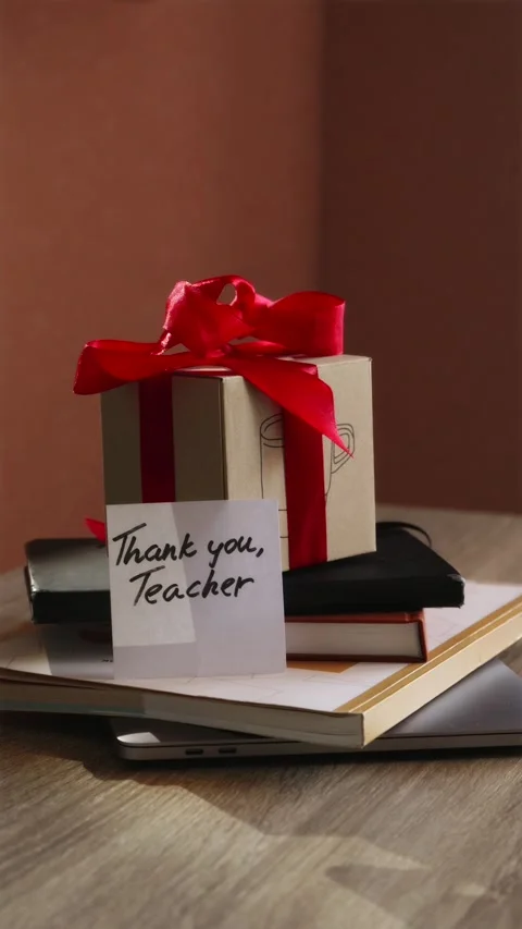 Placing gift box and Thank You Teacher card on desk vertical Stock Footage 340139054