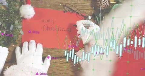 Placing gloved hands in red-fur sleeves holding red envelope on wooden tabletop Stock Photos
