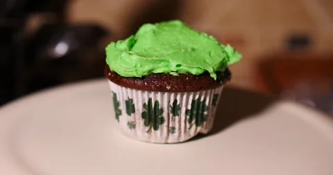 Placing Green cup cake with four leaf clovers on white plate Stock Footage 150607310