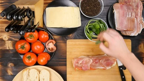 Placing greenary on sandwich in the kitchen Stock Footage 86235477