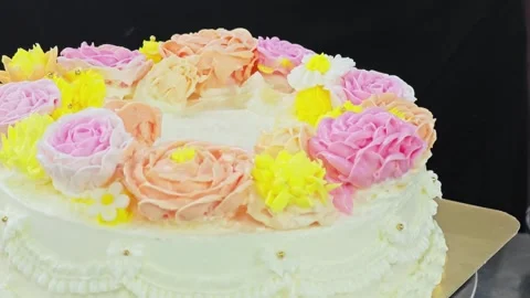 Placing hand-piped buttercream flowers onto a cake with lifter scissors. Vídeo Stock 344745520