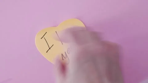 Placing a Heart-Shaped Post-It with "I Love You" Message Stock Footage 296898397