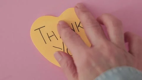 Placing a Heart-Shaped Post-It with "Thank You" Message Stock Footage 296898439
