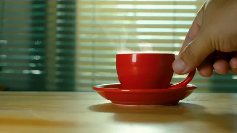 Placing hot red coffee cup on wooden table Stock Footage 163389427