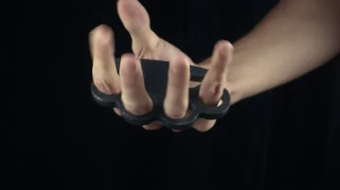 Placing knuckle-duster on the hand Stock Footage 68930586