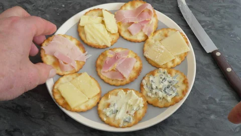 Placing last two cheese and ham crackers on a plate. Stock Footage 140981900