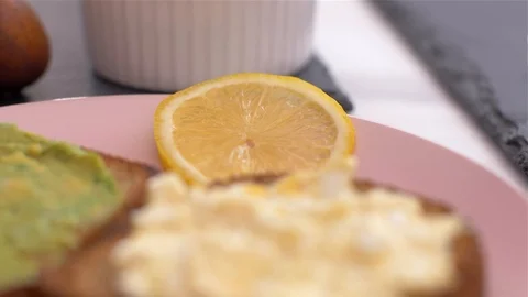 Placing a lemon on a  avocado toast Stock Footage 103653899