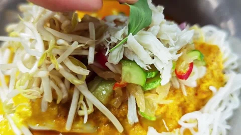 Placing lemon basil topping on Thai rice noodles with curry. Stock Footage 342516227