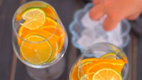 Placing lime slice and ice in a glass  . Preparing cocktails Video stock 110045016
