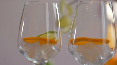 Placing lime slice in a glass with ice . Preparing cocktails Video stock 110039755